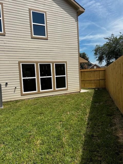 back of property featuring a fenced backyard and a lawn