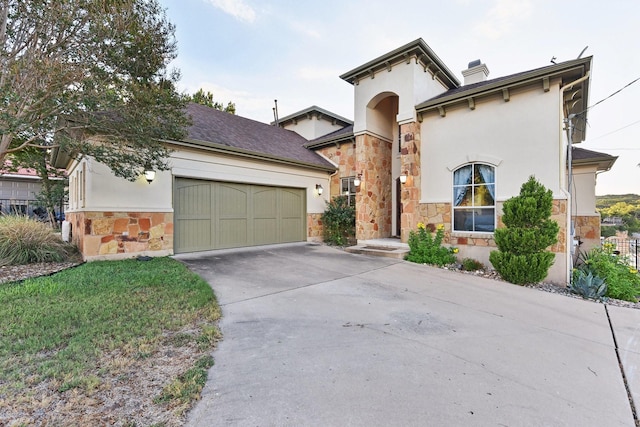 view of front of house with an attached garage, stone siding, concrete driveway, stucco siding, and a chimney