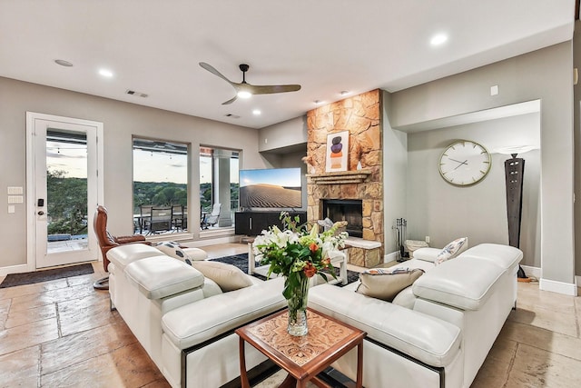 living room featuring baseboards, recessed lighting, a fireplace, and stone tile floors