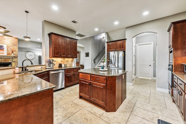 kitchen with visible vents, appliances with stainless steel finishes, arched walkways, and a sink