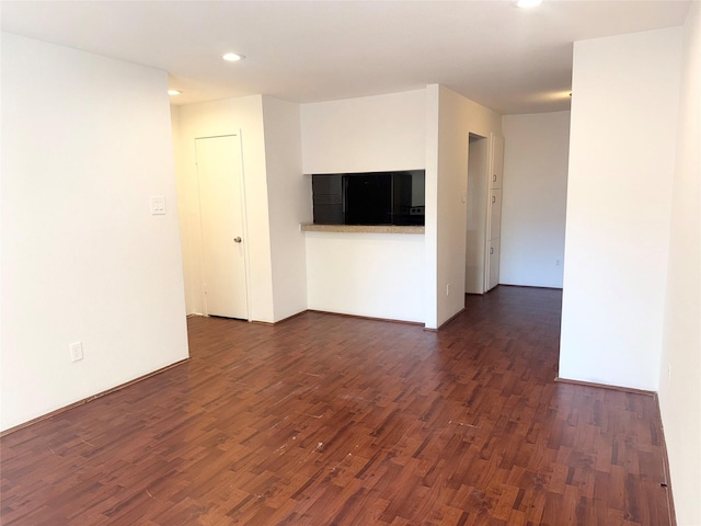 unfurnished room with dark wood finished floors and recessed lighting