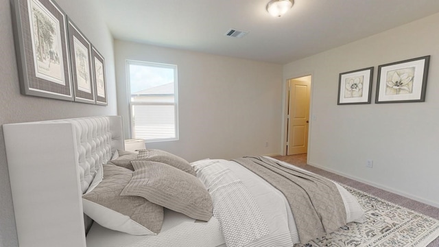 carpeted bedroom featuring visible vents and baseboards