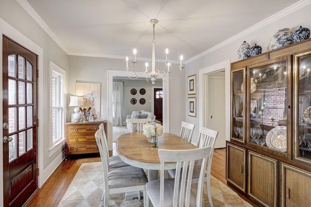 dining room with light wood-type flooring, an inviting chandelier, and a healthy amount of sunlight