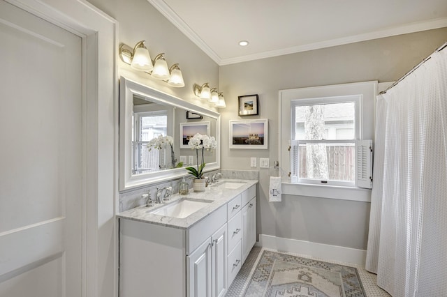 bathroom with double vanity, crown molding, baseboards, and a sink