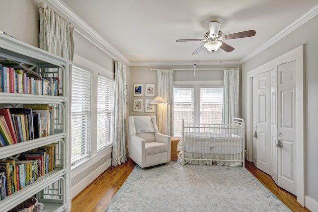 sitting room featuring baseboards, a ceiling fan, crown molding, and wood finished floors