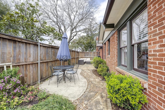 view of patio with central AC, outdoor dining space, and a fenced backyard