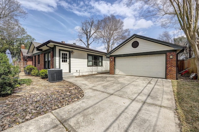 ranch-style house with cooling unit, brick siding, fence, and driveway