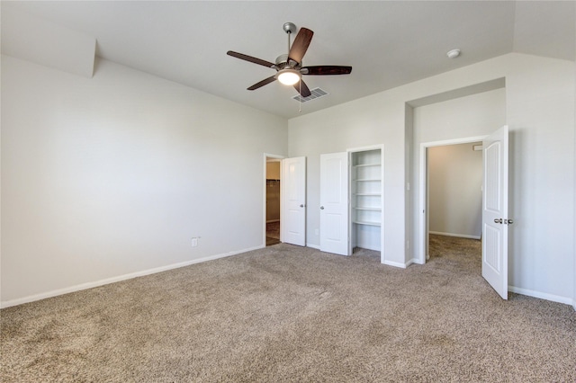 unfurnished bedroom with carpet, visible vents, a ceiling fan, vaulted ceiling, and baseboards