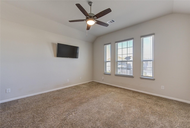 carpeted empty room featuring vaulted ceiling, a ceiling fan, visible vents, and baseboards