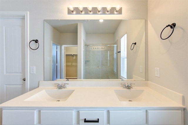 full bathroom with double vanity, a shower stall, a walk in closet, and a sink