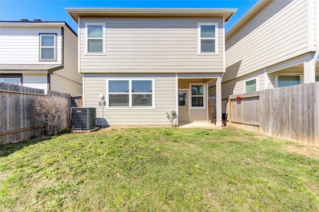 rear view of house with cooling unit, a fenced backyard, and a lawn