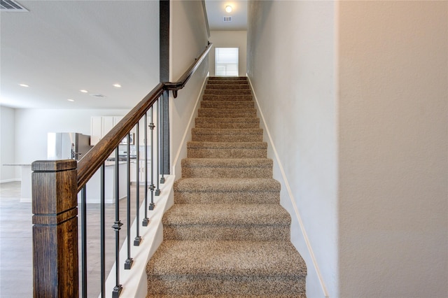 stairs with recessed lighting, wood finished floors, visible vents, and baseboards