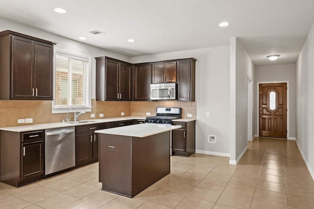 kitchen featuring stainless steel appliances, tasteful backsplash, light countertops, a sink, and dark brown cabinets