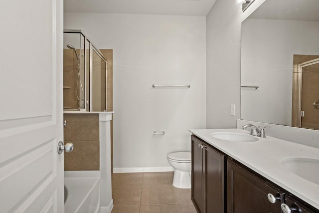 bathroom featuring double vanity, toilet, a sink, a shower stall, and tile patterned flooring