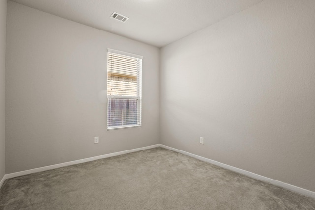 carpeted empty room featuring visible vents and baseboards