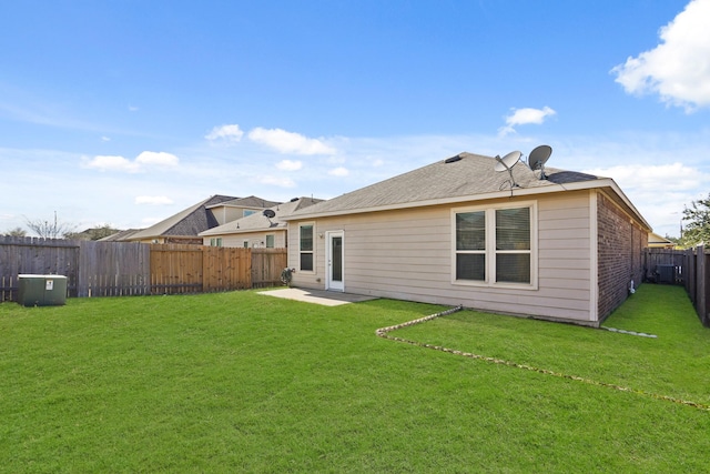 back of house featuring brick siding, a lawn, a patio area, and a fenced backyard