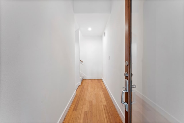 hall with light wood finished floors and baseboards