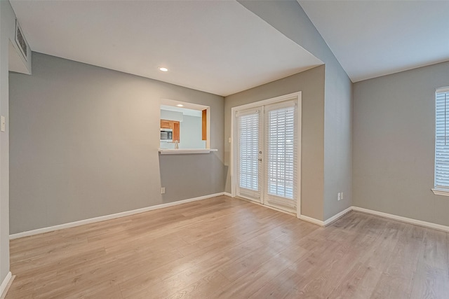 spare room featuring light wood-style flooring, recessed lighting, visible vents, baseboards, and french doors