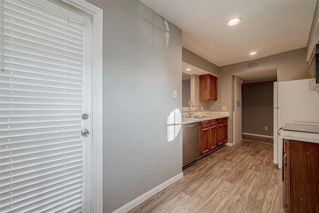 kitchen featuring light countertops, visible vents, light wood-style floors, a sink, and dishwasher