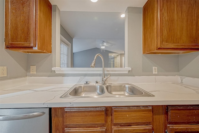 kitchen featuring brown cabinetry, ceiling fan, a sink, light countertops, and stainless steel dishwasher