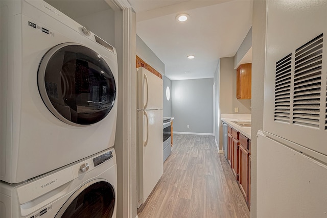 laundry area with stacked washer and clothes dryer, light wood finished floors, recessed lighting, laundry area, and baseboards