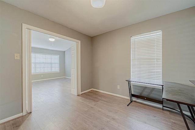 empty room with light wood-style flooring and baseboards