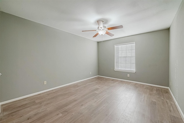 spare room with light wood-style floors, baseboards, and a ceiling fan