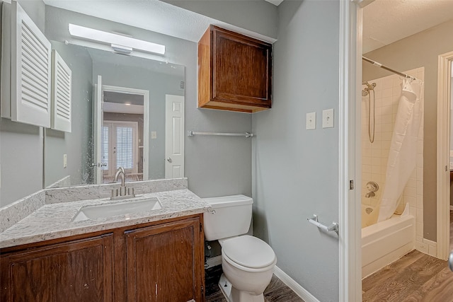 bathroom featuring shower / tub combo, baseboards, toilet, wood finished floors, and vanity