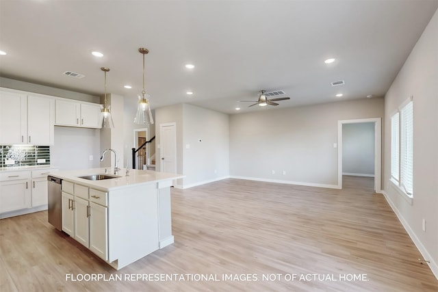 kitchen with stainless steel dishwasher, visible vents, light wood finished floors, and a sink