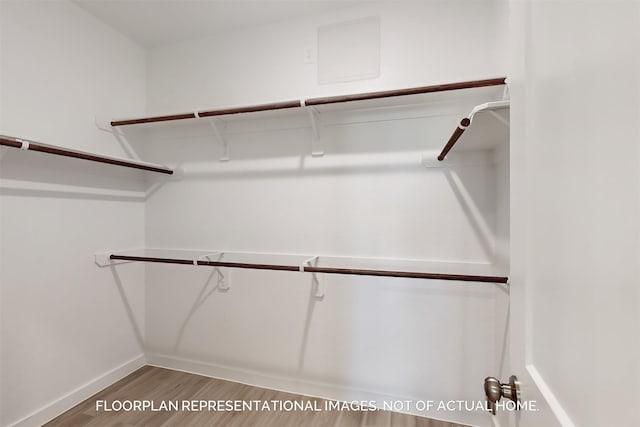 walk in closet with wood finished floors