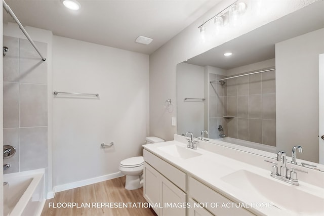 full bathroom featuring wood finished floors, shower / bath combination, a sink, and toilet