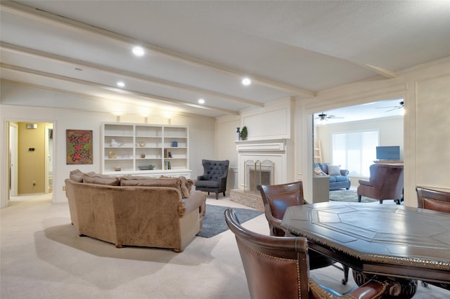 living area featuring light carpet, a fireplace with raised hearth, beam ceiling, and recessed lighting