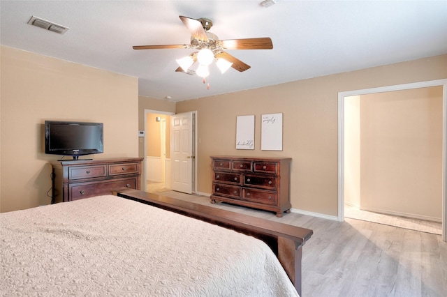 bedroom featuring a ceiling fan, visible vents, light wood-style flooring, and baseboards