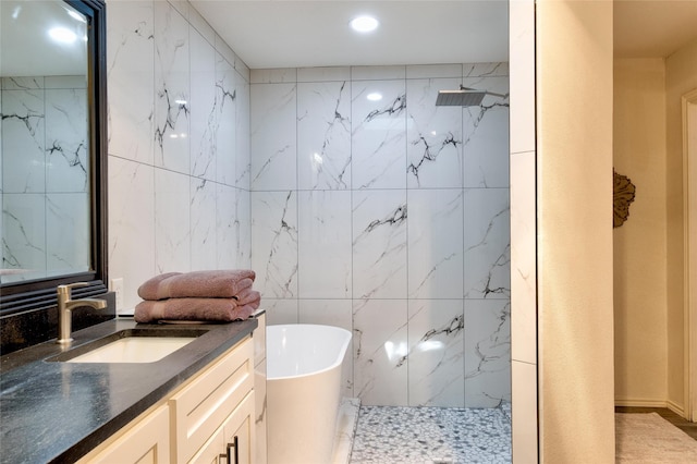 bathroom with a marble finish shower, tile walls, a freestanding bath, and vanity