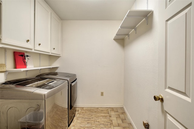 laundry room with cabinet space, baseboards, and separate washer and dryer