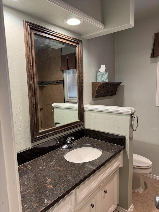 bathroom with recessed lighting, toilet, vanity, baseboards, and tile patterned floors