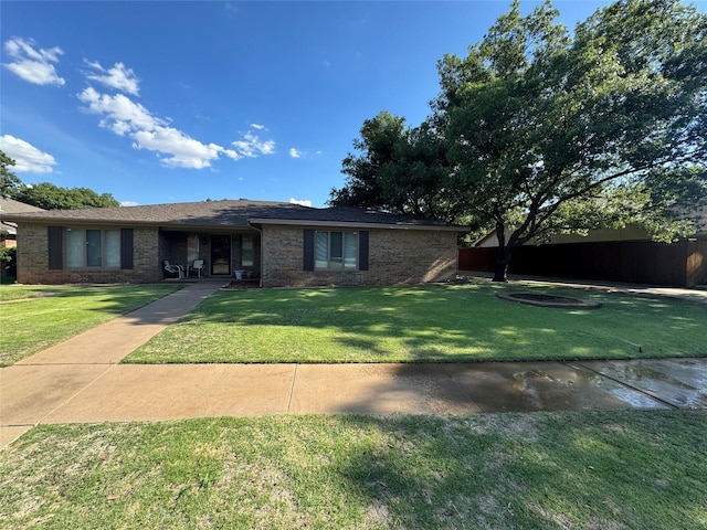 ranch-style home featuring a front lawn and brick siding