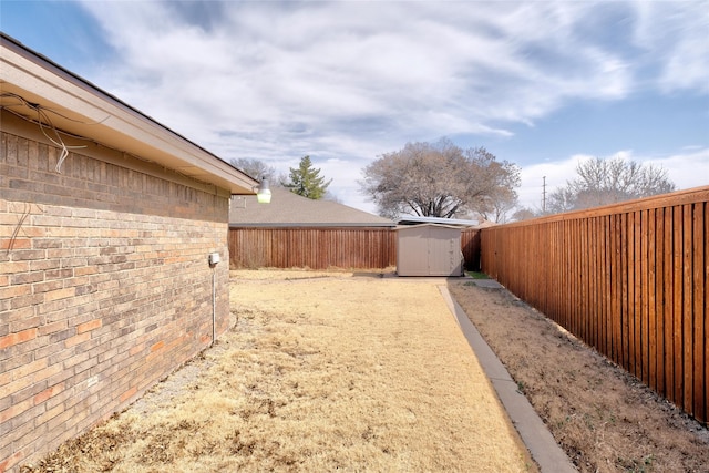 view of yard with an outbuilding, a fenced backyard, and a shed