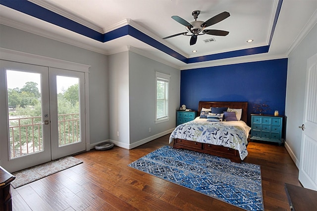 bedroom with access to exterior, wood-type flooring, a tray ceiling, and french doors