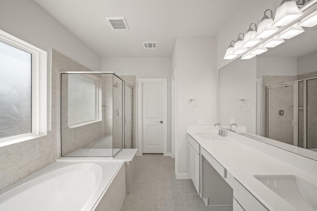 full bath with plenty of natural light, a shower stall, visible vents, and a sink