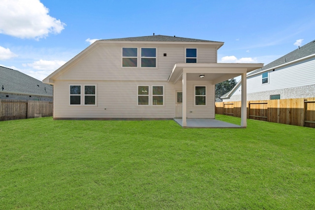 rear view of property featuring a fenced backyard, a lawn, and a patio