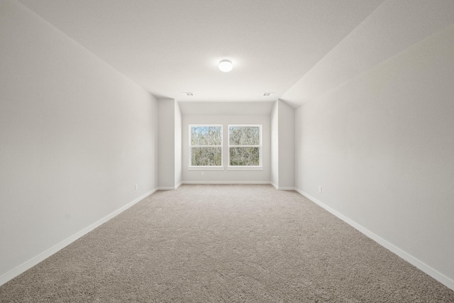 unfurnished room with visible vents, baseboards, and light colored carpet