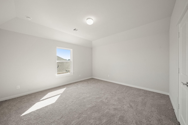 carpeted spare room with visible vents and baseboards