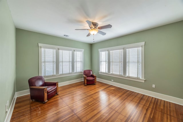 unfurnished room with visible vents, ceiling fan, baseboards, and wood finished floors