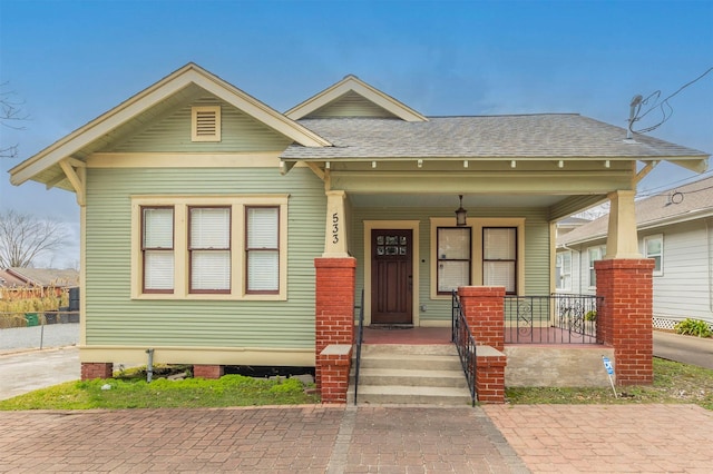 view of front of property featuring a shingled roof and a porch