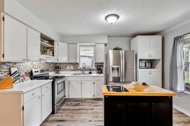 kitchen featuring white cabinets, tasteful backsplash, stainless steel appliances, and a sink