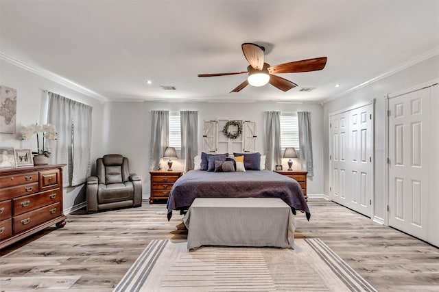 bedroom with light wood-style flooring, multiple windows, visible vents, and crown molding