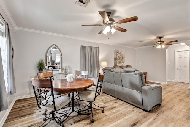 dining room featuring visible vents, crown molding, and light wood-style flooring