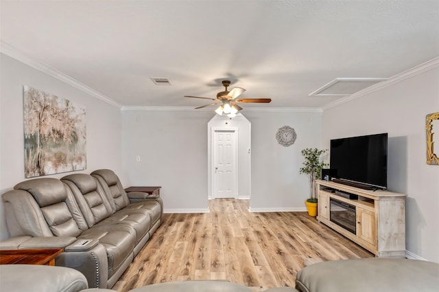 living room featuring baseboards, crown molding, and light wood finished floors