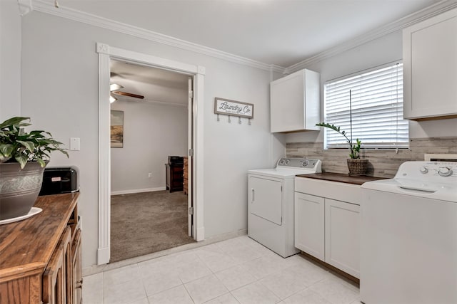 clothes washing area with cabinet space, ornamental molding, and washer and clothes dryer